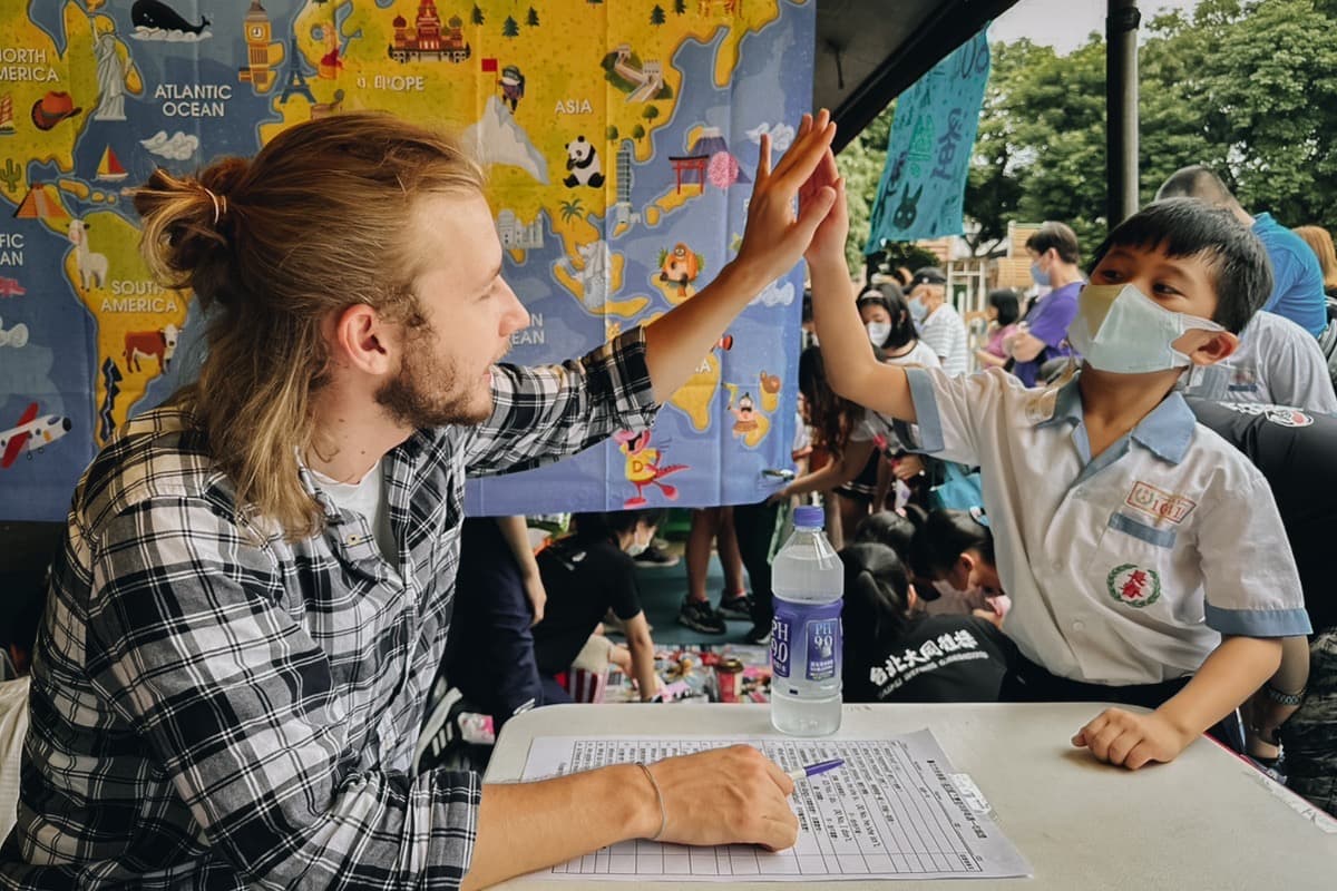 Teacher high-fiving a student at an English event