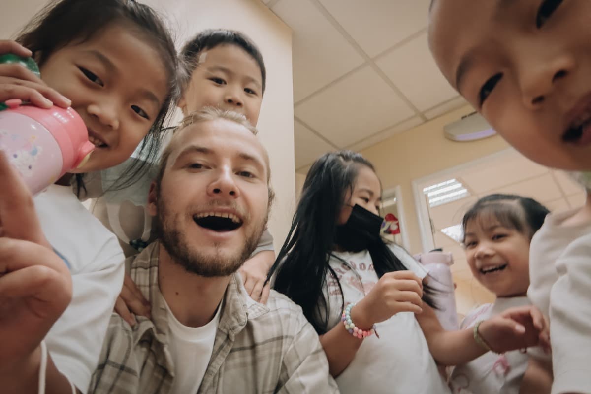 Teacher surrounded by smiling kids in a classroom