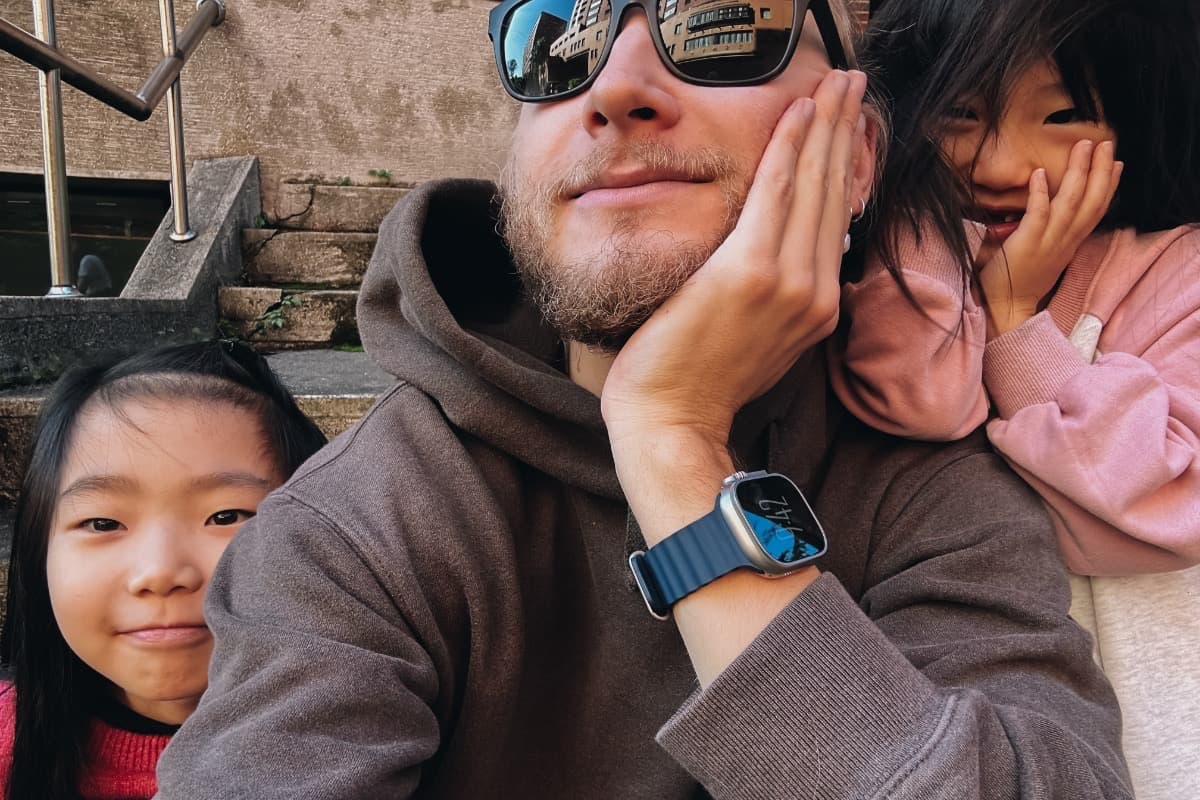 Teacher posing with young students outdoors